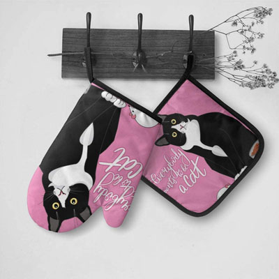 tuxedo cat over mitts and pot holders
